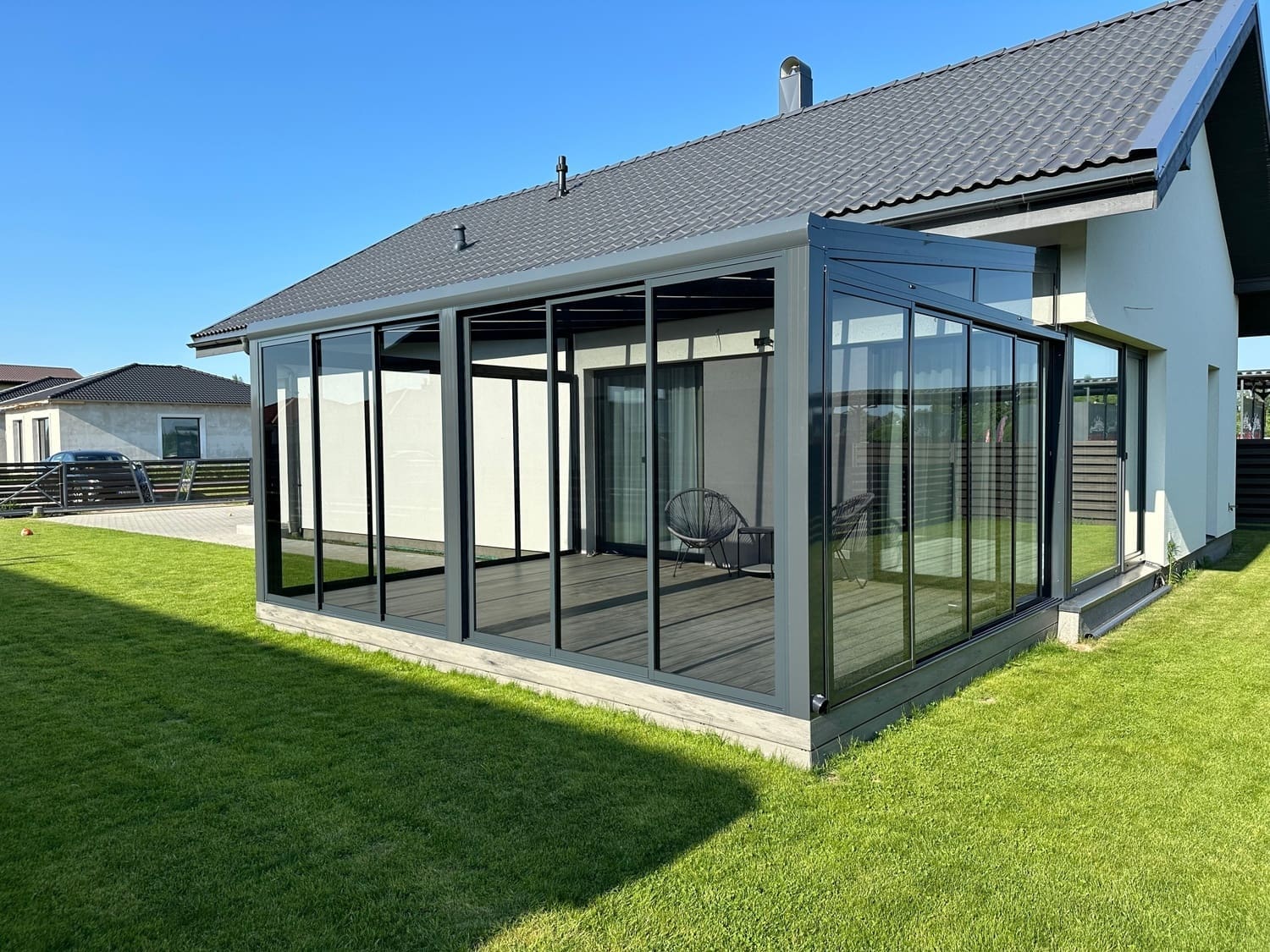 Fully enclosed aluminium pergola with sliding glass doors open creating indoor outdoor garden space