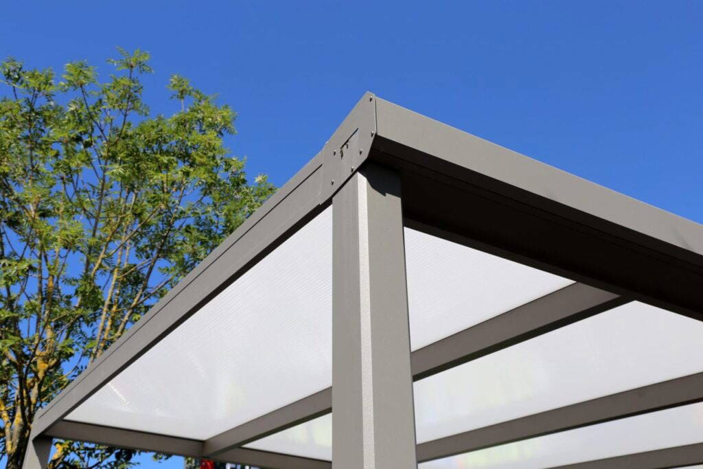 Aluminium pergola with polycarbonate roof providing covered outdoor seating area by Superior Pergola Ireland